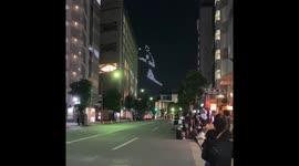 Floating pictograms of athletes appear in Tokyo's night sky