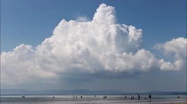 Storm Clouds/Convection Bubbling Up Under Capping Inversion During Hot Weather At Busy Beach