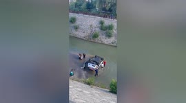 Residents in China rush into river to rescue motorist trapped in overturned car