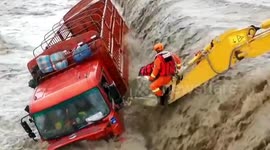 Chinese firefighters use excavator to rescue driver trapped in truck surrounded by floodwater