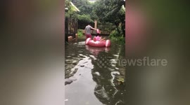 Dad takes kids for ride on inflatable toy through submerged streets in eastern China