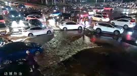 Police officer stands barefoot in flooded road to direct traffic after water pipe explodes in China