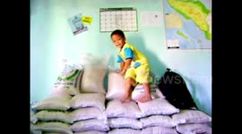 A little boy learning how to jump off his parents pile of rice.