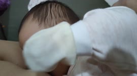 Funny newborn baby attempts to suck dad's nipple when dad is holding her on hand