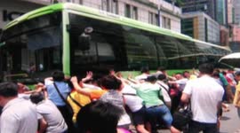 Bystanders lift bus to save elderly woman