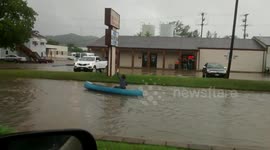 Man canoes down flooded road in Athens, Ohio