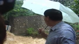Floodwater rips down wall in middle of interview