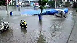 Metal canopy ripped off by strong winds narrowly misses three-wheeler in central China