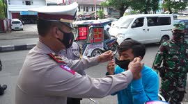 Armed police officers conduct mask raids on streets in Makassar City