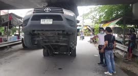 Careless truck driver gets stuck under low bridge in Thailand