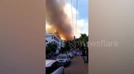 Wildfire burns through hillside forest near tourist hotels in Turkey