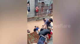 Neighbours save grandmother who fainted during a flood in the Philippines
