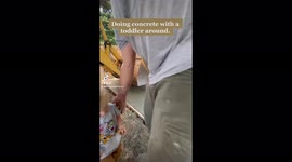 Pouring concrete with a toddler around. Father working on concrete with son