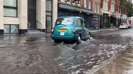London taxis splash through flooded streets as flash floods hit the city again