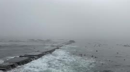 Fog rolls in over Mouille Point, Cape Town. Public enjoy outdoors