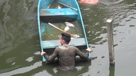 The big catch, fishermen in the water and fish in the boats, on this pond in Thailand.