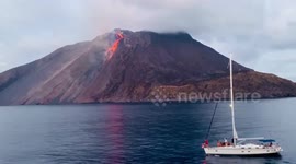 Watch the sailing boat in front of Etna volcano eruption in Italy