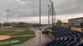 Gusty winds from severe storm blow off tarp from baseball field