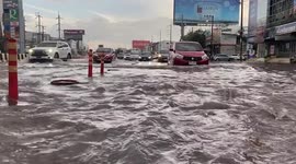 Cars drive through floods after heavy rain in Thailand