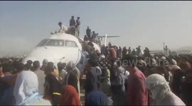 New footage emerges from Kabul airport showing scores of Afghans clinging to outside of plane