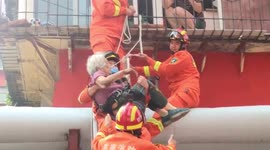 Firefighters rescue elderly woman dangling from window in eastern China