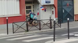 Funny Deliveroo rider cruising the streets of Paris with a grand french flag mounted on a mast on his bike.21aug2021