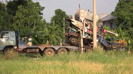 A rice harvesting machine at work in a paddy field in Thailand.