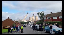 Crowd watches chimney stacks being demolished in Ferrybridge, West Yorkshire