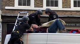 Extinction Rebellion protester glues himself to a van in central London