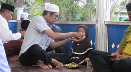 A Great Father Feeding His Daughter in A Ceremony