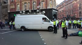 A Police van issues a warning people leave the area and women is arrested for falling to move during the Extinction Rebellion The Impossible Rebellion protest