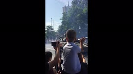 Boy waves to passing tanks at the parade on Ukraine's Independence Day
