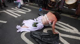 Women dressed as Mother Earth crawls on the floor - third day of Extinction Rebellion protests outside Brazilian Embassy in London