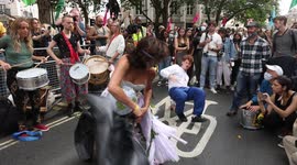 Street Dance stunt by Extinction Rebellion protestors featuring women dressed in white gown dancing to drums at the Brazilian embassy in London