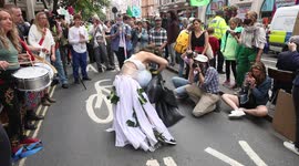 Women dressed as a bride plays traumatised Earth on day 3 of extinction rebellion's protests outside the Brazilian Embassy in London