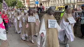 Extinction Rebellion 'penitents' with placards state their 'sins'