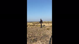 Base jumper jumps from 300ft cliff in southern Idaho, USA then deploys parachute and lands safely below.
