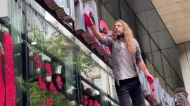 Watch moment XR protester daubs Standard Chartered logo in red paint in City of London
