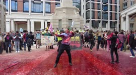 An Extinction Rebellion protester dances in Paternoster Square which was covered in fake blood  durning their Blood Money March