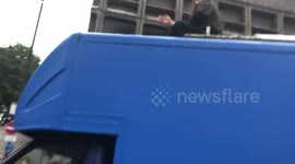 Extinction Rebellion protestors locked on to roof of lorry during protest in London and man with bicycle gets pushed by police