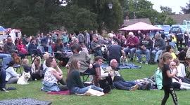 Visitors to a bandstand concert enjoying the music, picnics and ice creams in an Oakham park in the UK
