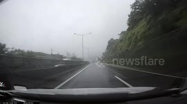 SLIPPERY ROADS: Car starts to hydroplane causing it to swerve into the roadside barrier