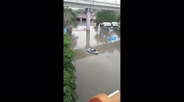 People sail on a boat in the flooded Delhi, India