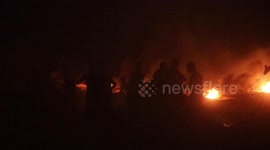 Palestinians burn tires during night protest along the border fence with Israel