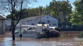 Floodwaters inundate streets and swamp vehicles in Bridgeport, PA, leaving mud and debris