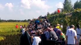 Sightseeing train full of passengers tips over in rice field in China, injuring 2