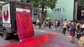 Art attack: Thai anti-government protesters hang mock corpses and throw fake blood at PM's image