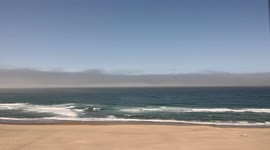 Watch as this beautiful, sunny Pacific Ocean shoreline is engulfed by a thick sea fog
