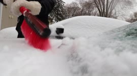 Close-Up View of Person Removing ice covered with snow From His/Her Car
