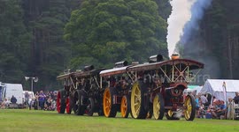 A train of vintage steam tractors being pulled around an arena in Yorkshire